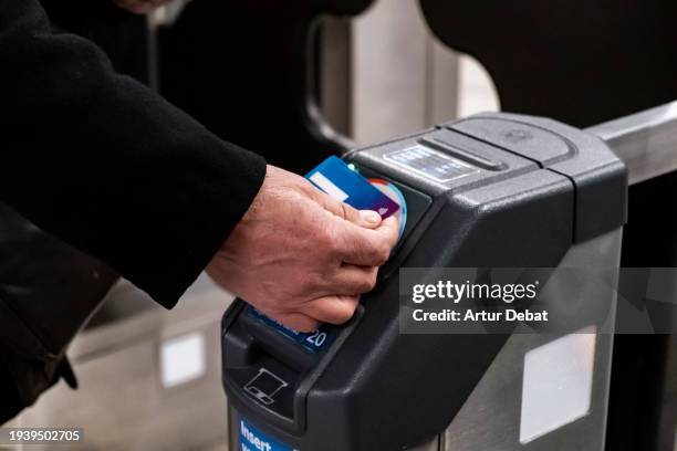 senior man paying with contactless credit card on the subway station. - train ticket stock pictures, royalty-free photos & images