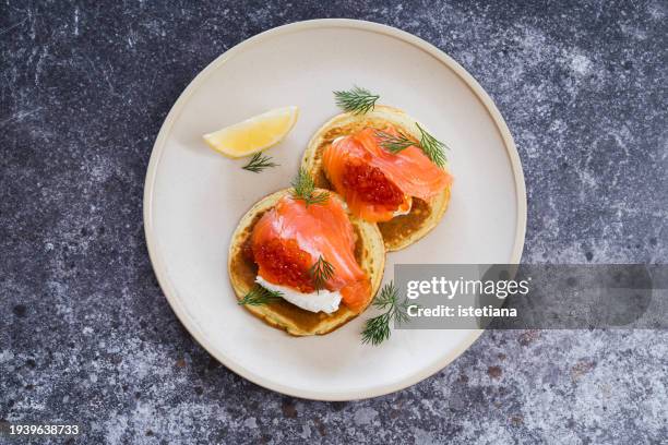 blinis with smoked salmon, white cheese, red caviar, garnished with dill - trout stock pictures, royalty-free photos & images