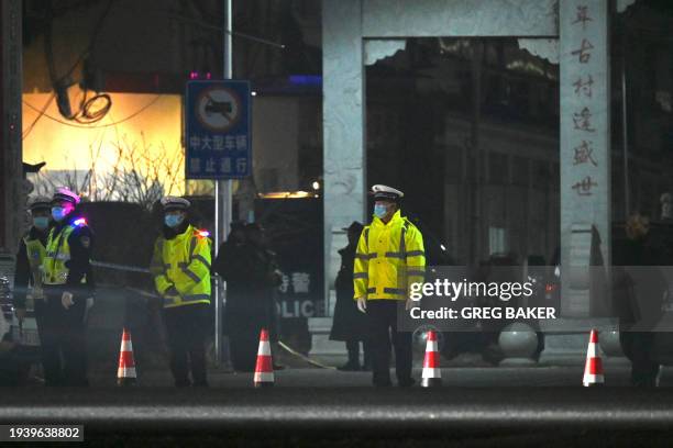 Police stand outside a school where 13 people died in a fire in Yanshanpu in China's central Henan province on January 20, 2024. Thirteen...