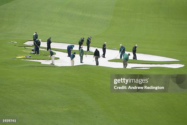 Greenkeepers repair the bunker on the tenth hole before play can start during the first day of the 2003 Masters Tournament at the Augusta National...