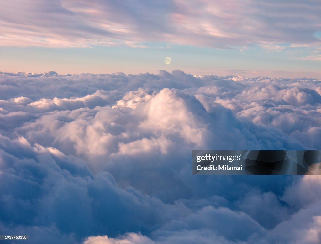 Romantic clouds and moon at sunset