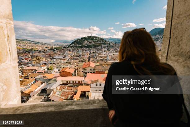 woman looking at the views of the historic district / old town of quito (ecuador) seen from above from the basilica del voto nacional - house golden hour stock pictures, royalty-free photos & images