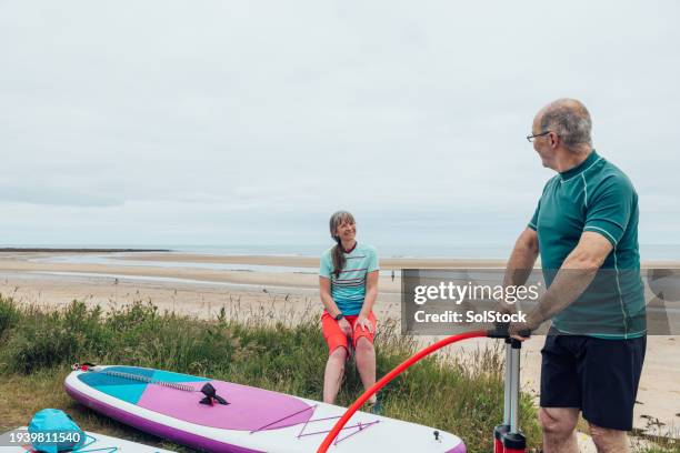 blowing up the paddle boards - air pump stock pictures, royalty-free photos & images