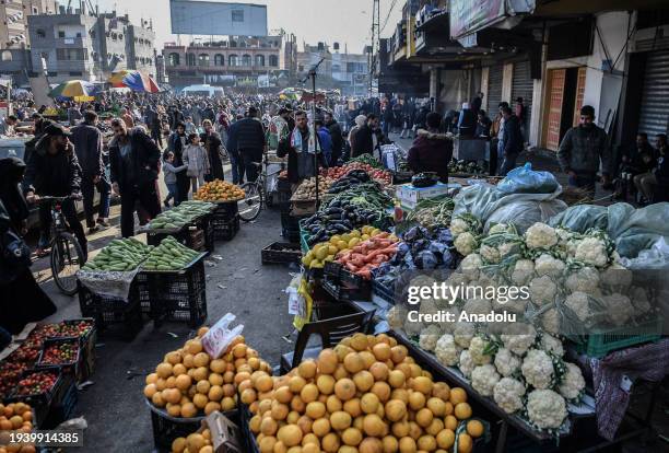 Palestinians shop for food and clothes at the local bazaar as Palestinian families who had to leave their homes continue their lives in the tent city...