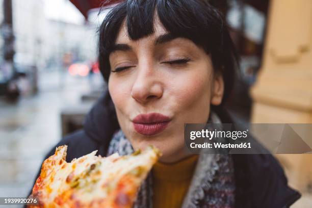 woman enjoying pizza with eyes closed - hungry people stock pictures, royalty-free photos & images
