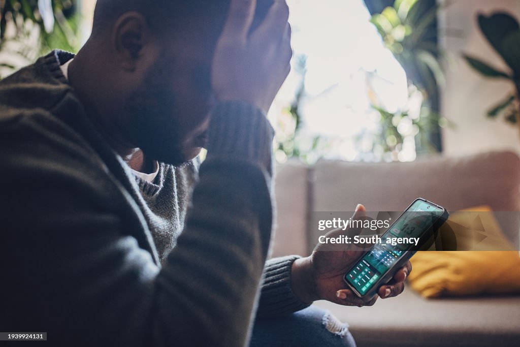 Man Engrossed in Live Sports Betting on Smartphone