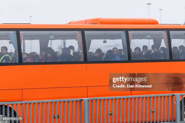 Migrants leave Dover harbour in a bus after being picked up in the English Channel by a Border Force vessel on January 17, 2024 in Dover, England....