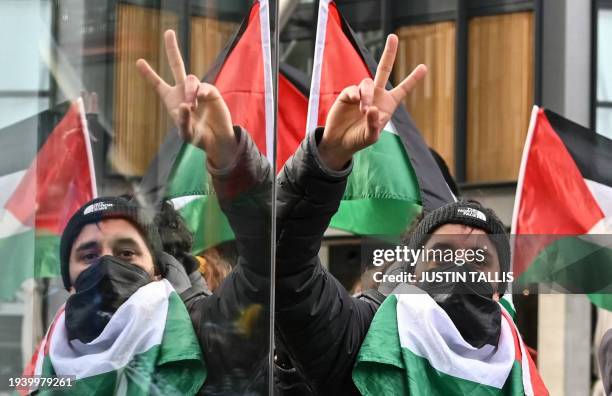 Pro-Palestinian supporter gestures as he is reflected on a window during a "Day of Action for Palestine" demonstration outside the British...