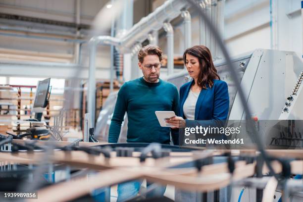 engineers discussing over tablet computer in industry - usine photos et images de collection