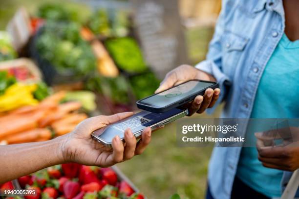 kunde, der kontaktlos auf einem bauernmarkt bezahlt - mobile zahlung stock-fotos und bilder