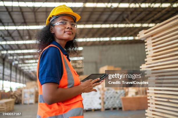 managers controlling distribution and checking inventory in warehouse storage. worker are working at lumber yard in large warehouse. lumber and inventory check at storage shelves in lumberyard. - construction-worker stockfoto's en -beelden