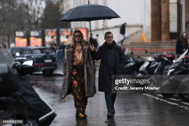 Bill Kaulitz seen wearing Gucci brown tortoise pilot sunglasses, gold piercings, gold earrings / hoops, gold necklaces, light orange satin / silk...