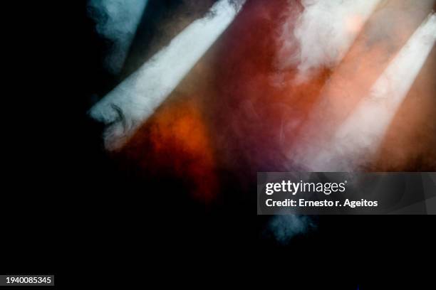 light beams crossing smoke against a black background - luz de palco imagens e fotografias de stock