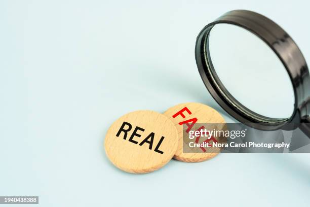 magnifying glass and text real fake - information equipment stock pictures, royalty-free photos & images