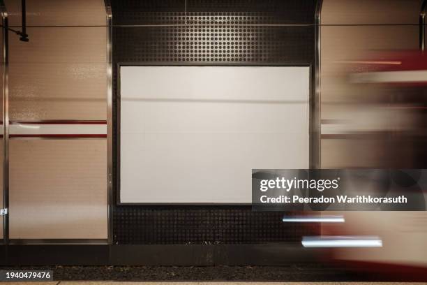 urban commute canvas: blank billboard on subway platform awaiting advertiser. - railway station signage stock pictures, royalty-free photos & images