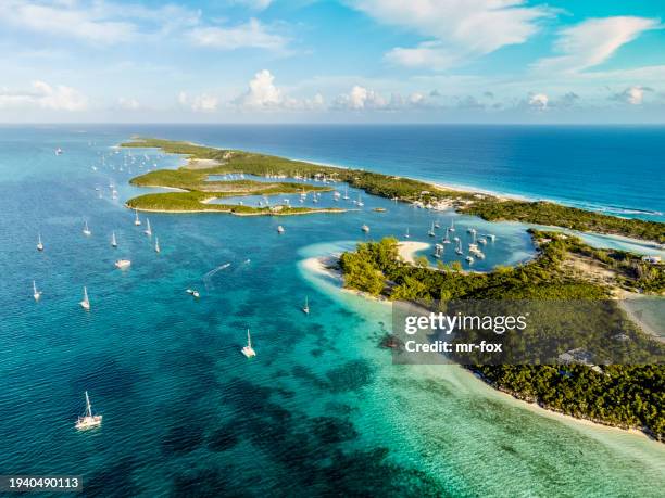 beautiful aerial view of famous chat'n'chill conch bar in stocking island (exuma - bahamas) near george town with many boats and sailing yachts anchored - caribbean sea stock pictures, royalty-free photos & images