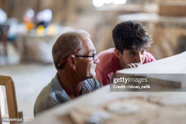grandfather and grandson in workshop - grandpa son stock pictures, royalty-free photos & images