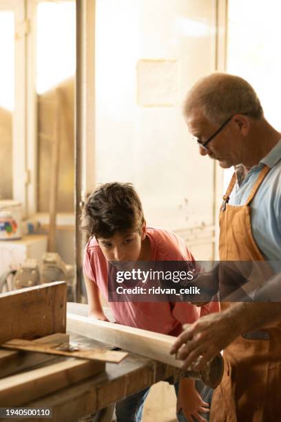 grandfather and grandson in workshop - großvater vater sohn business stock-fotos und bilder