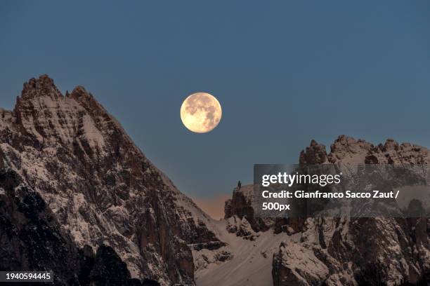 scenic view of snowcapped mountains against clear sky at night - vollmond stock-fotos und bilder
