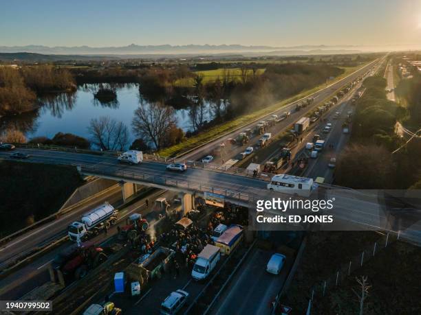 This aerial photograph taken on January 20 shows farmers blocking the highway A64, to protest against taxation and declining income, near Carbonne,...