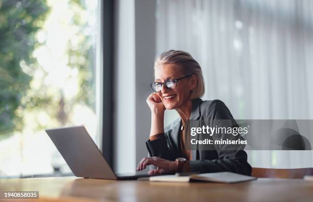 portrait d’une femme d’affaires senior travaillant au bureau et utilisant un ordinateur portable - baby boomer photos et images de collection