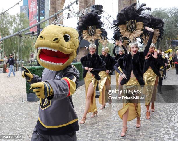 The Vegas Golden Knights mascot Chance the Golden Gila Monster and members of the Golden Belles showgirl team participate in The March to the...