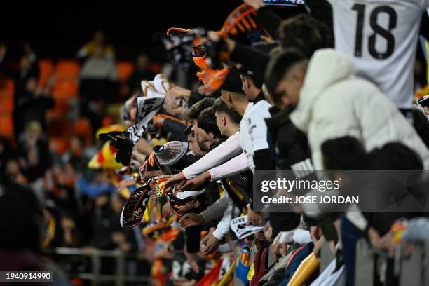 Supporters cheer during the Spanish League football match between Valencia CF and Athletic Club Bilbao at the Mestalla stadium in Valencia on January...