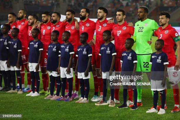Tunisia's players stand for their national anthem before the Africa Cup of Nations 2024 group E football match between Tunisia and Mali at the Amadou...