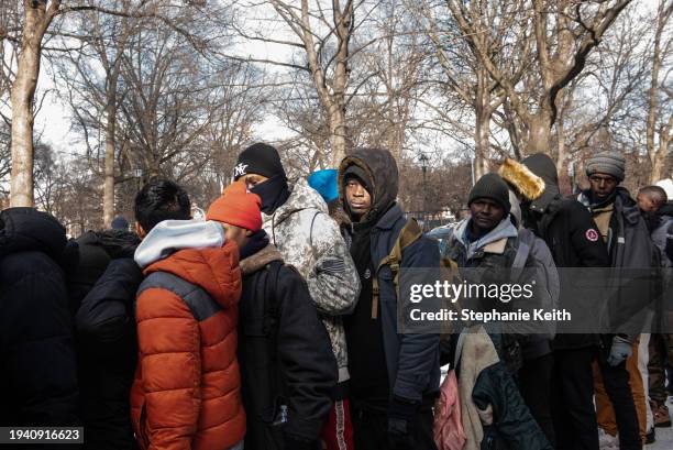 Homeless migrants wait in line to receive food and clothing donations in Tompkins Square Park on January 20, 2024 in New York City. Last month, the...