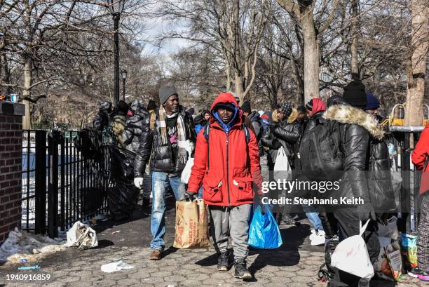 Homeless migrants receive food and clothing donations in Tompkins Square Park on January 20, 2024 in New York City. Last month, New York City imposed...