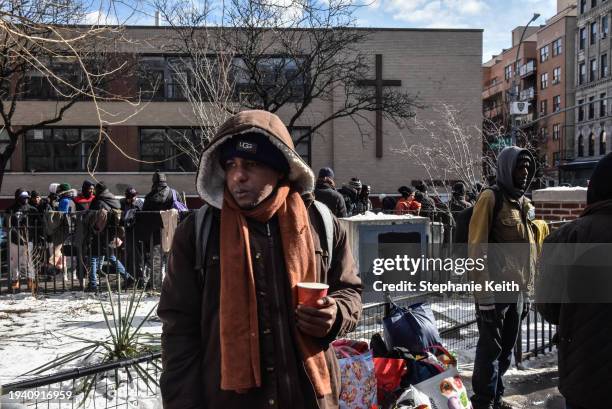 Homeless migrants look on as food and clothing donations are distributed in Tompkins Square Park on January 20, 2024 in New York City. Last month,...