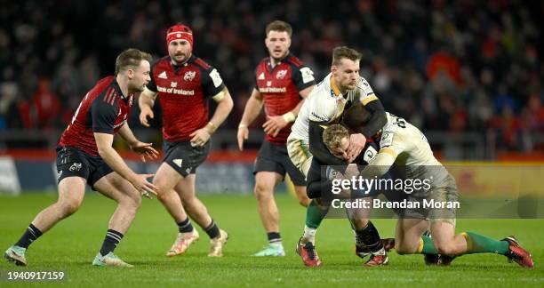 Limerick , Ireland - 20 January 2024; Craig Casey of Munster is tackled by Rory Hutchinson and Fraser Dingwall of Northampton Saints during the...