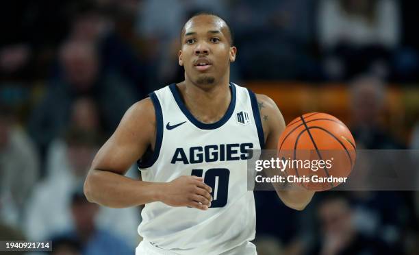 Darius Brown II of the Utah State Aggies brings the ball up the court against the Fresno State Bulldogs during the first half of their game at Dee...