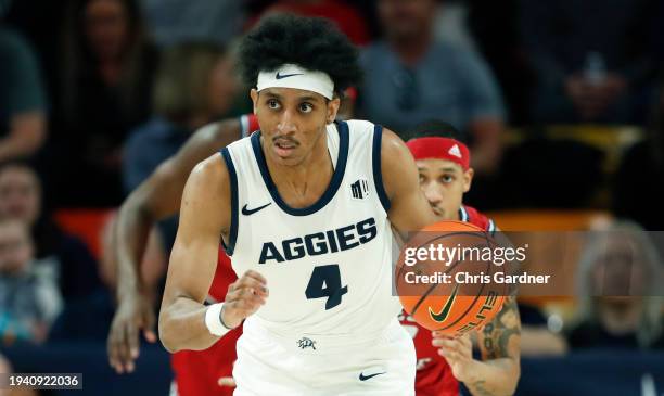 Ian Martinez of the Utah State Aggies pushes the ball up the court against the Fresno State Bulldogs during the first half of their game at Dee Glen...