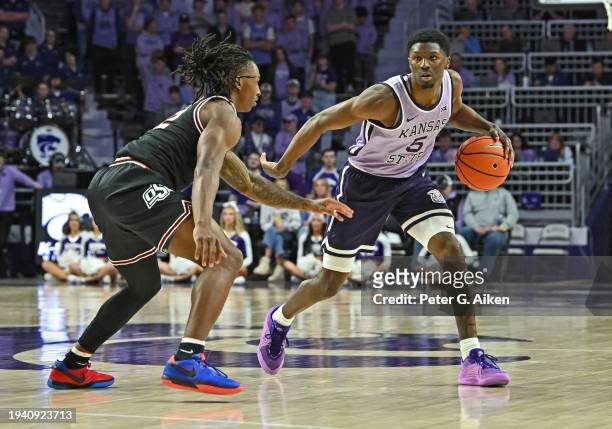 Cam Carter of the Kansas State Wildcats dribbles the ball against Javon Small of the Oklahoma State Cowboys in the second half at Bramlage Coliseum...