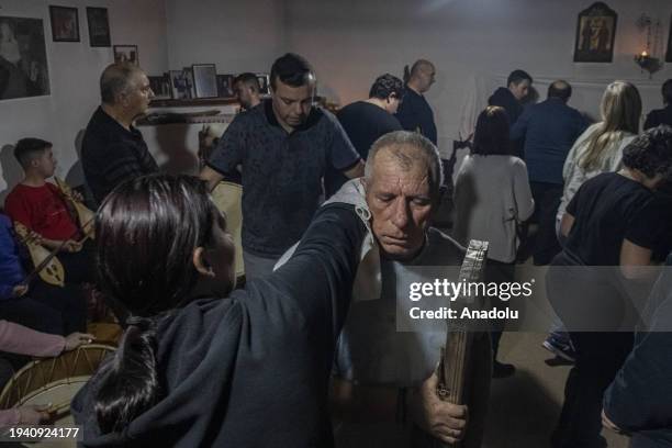 Woman puts a towel on the shoulders of man, carrying historical holly items of the Christian Greek Orthodox Saints Constantine and Helen, as he...