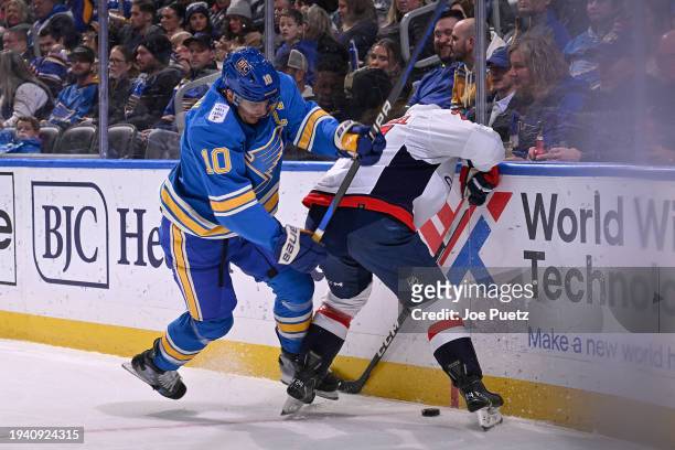 Brayden Schenn of the St. Louis Blues battles Connor McMichael of the Washington Capitals for the puck on January 20, 2024 at the Enterprise Center...