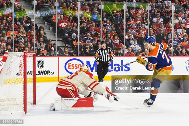 Ryan McLeod of the Edmonton Oilers scores on Daniel Vladar of the Calgary Flames during the first period of an NHL game at Scotiabank Saddledome on...