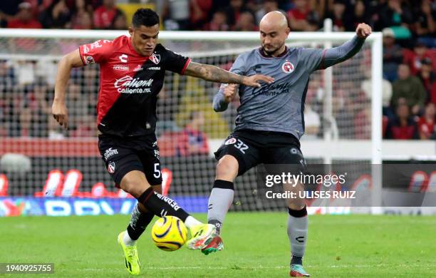 Anderson Santamaria of Atlas vies for the ball with Carlos Gonzalez of Tijuana during their Mexican Clausura tournament football match at the Jalisco...