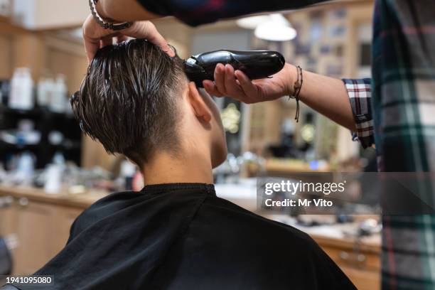 un adolescente cortándose el pelo en la peluquería - cortar pelo fotografías e imágenes de stock