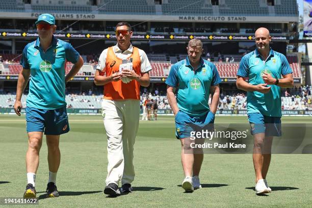 Andrew McDonald, head coach of Australia, Scott Boland, Scott Burns and Matthew Nicks of the Adelaide Crows Football Club walk from the field at the...
