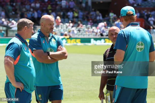 Scott Burns and Matthew Nicks of the Adelaide Crows Football Club look on as Andrew McDonald, head coach of Australia talks with Head Curator, Damian...