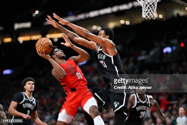 Scoot Henderson of the Portland Trail Blazers is well guarded by Nic Claxton of the Brooklyn Nets during the third quarter at the Moda Center on...
