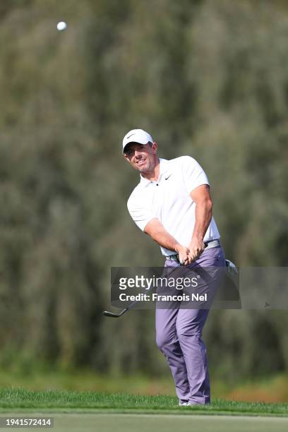 Rory McIlroy of Northern Ireland plays a chip shot on the 17th hole during Round One of the Hero Dubai Desert Classic at Emirates Golf Club on...