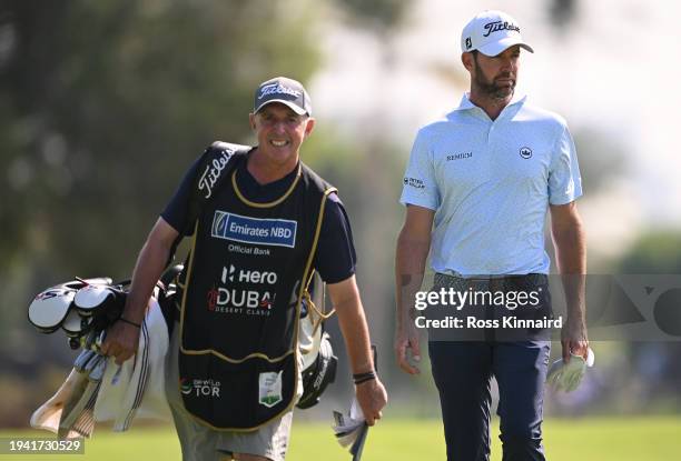 Scott Jamieson of Scotland walks with his caddie Phil "Wobbly" Morbey on the 18th hole on day one of the Hero Dubai Desert Classic at Emirates Golf...