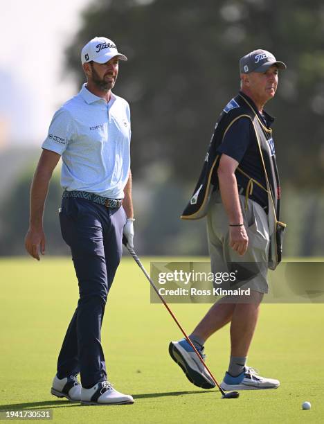 Scott Jamieson of Scotland walks with his caddie Phil "Wobbly" Morbey on the 18th hole on day one of the Hero Dubai Desert Classic at Emirates Golf...