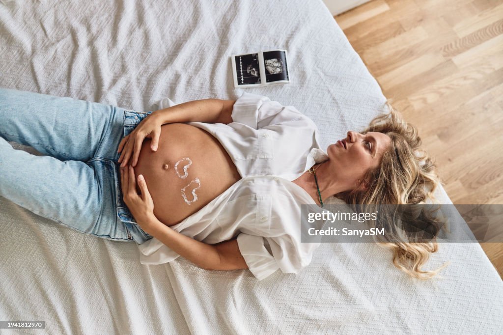Pregnant woman embracing her belly