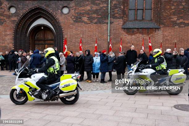 Police officers secure the area as people queue before attending a service with the participation of the royal family on the occasion of the change...