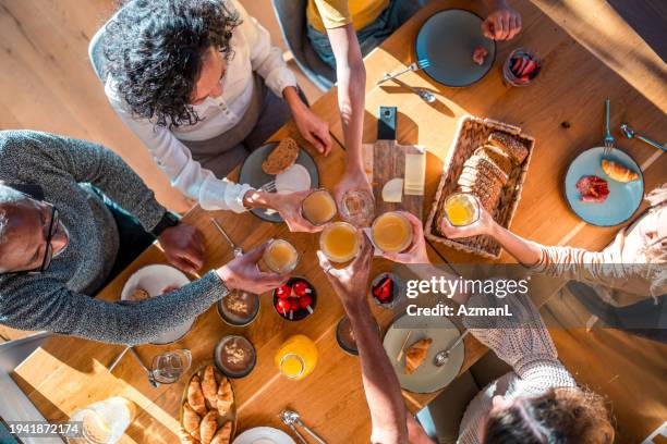 familia diversa disfrutando de la comida juntos - brunch fotografías e imágenes de stock