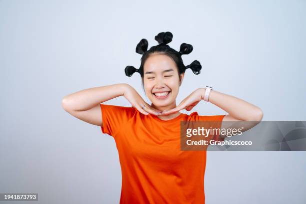 young asian woman with many bun hair and smiling at camera on white background - hair bun how to stock pictures, royalty-free photos & images
